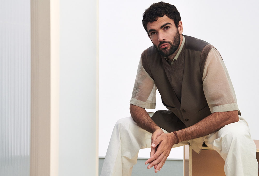 Matteo Berrettini sitting on a wooden box and poses in front of a white background (photo)