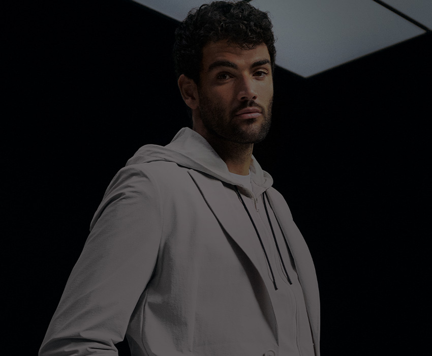 BOSS Performance – Matteo Berrettini dressed in white, posing in front of a black background, zoomed in (photo)